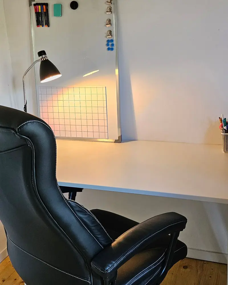 Locul copilului la masa de lucru, cu tabla mică și lampa în față